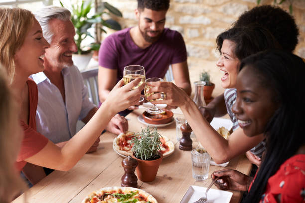 istock Smiling friends eating at a table in a cafe making a toast 1068362296