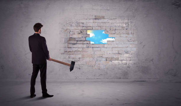 istock Business man hitting brick wall with hammer 1068362548