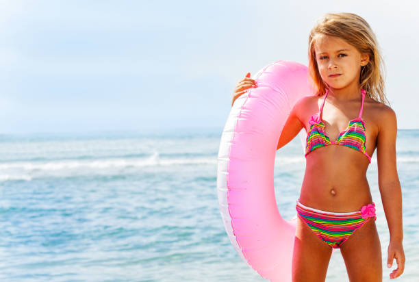 istock Beautiful girl posing with swim ring on the beach 1068362848