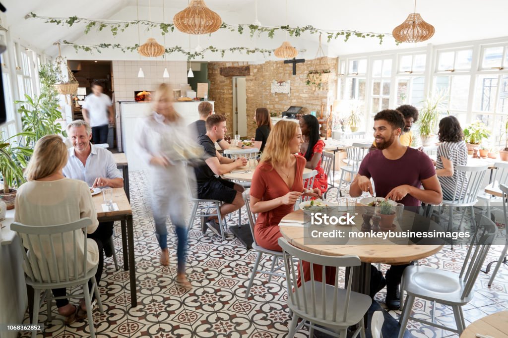 Clientes na hora do almoço, comendo em um restaurante movimentado - Foto de stock de Restaurante royalty-free