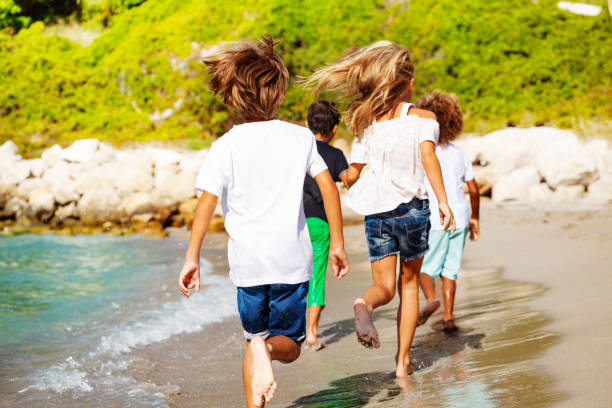 istock Kids running away along sandy beach in summer 1068363018