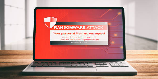 Ransomware attack on a computer laptop screen, wooden desk. 3d illustration Ransomware, virus attack alert on a computer laptop screen, wooden desk, blur office background, front view. 3d illustration ransomware stock pictures, royalty-free photos & images
