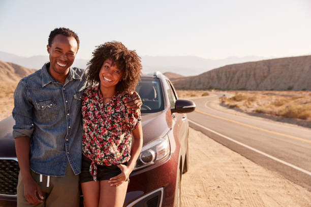 istock Young black couple standing on desert roadside by their car 1068365556