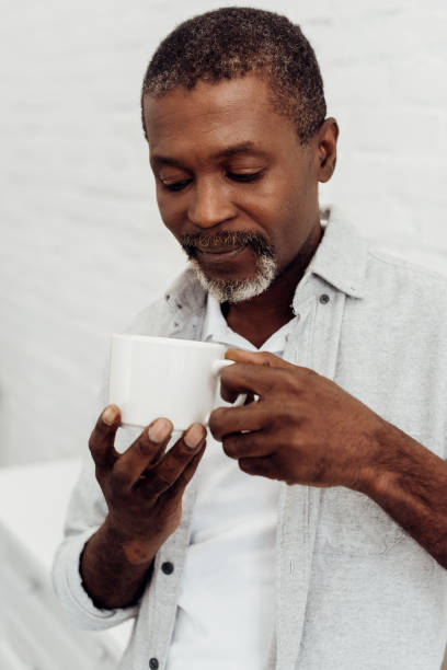 istock african american mature man holding white cup 1068370350