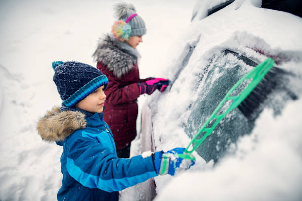 istock Children removing snow from car after heavy snowing 1068370356