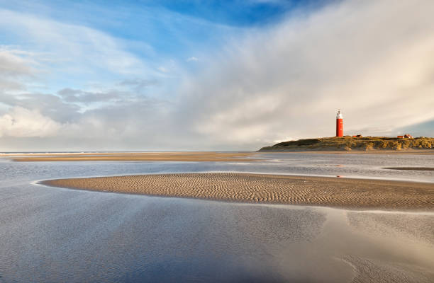 istock high tide on sand beach by red lighthouse 1068373064