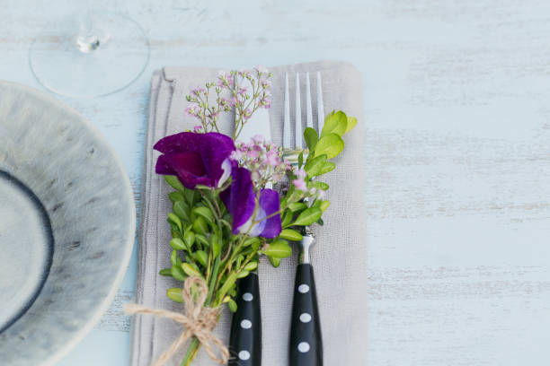 istock Rustic table setting with purple flowers on light wooden table. 1068378722