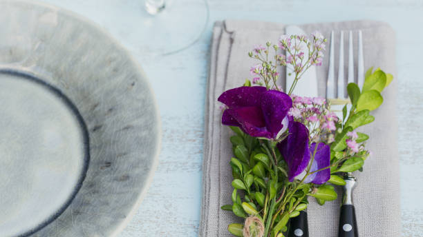 istock Rustic table setting with purple flowers on light wooden table. 1068378740