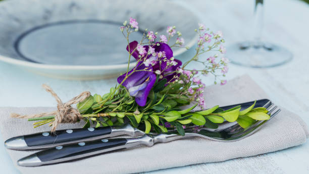 istock Rustic table setting with purple flowers on light wooden table. 1068378750