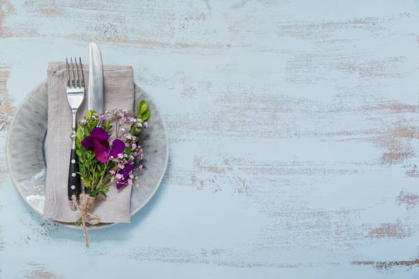 istock Rustic table setting with purple flowers on light wooden table. 1068378752