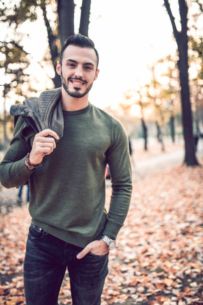 istock Handsome Male Model Posing In Park On Autumn Morning 1068378860
