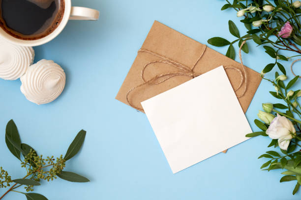 istock Flowers, craft envelope, cup of coffee on blue background with copy space for your text. Mockup for banner, greeting card. Woman's day, 8 march, wedding, dating, love concept. Flat lay, top view. 1068378918