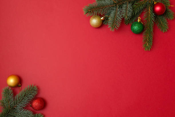 istock Christmas holidays composition on red background with copy space for your text. Xmas tree fir branches with balls in the corners, Xmas backdrop for greeting card. Flat lay, top view, overhead 1068379178