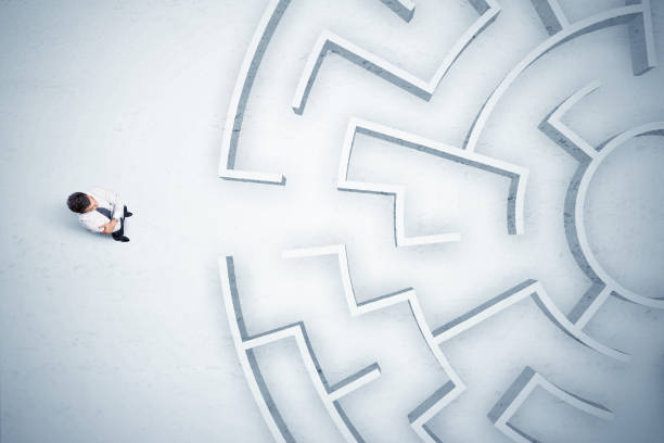 istock Business man looking at circular maze with nowhere to go 1068382208