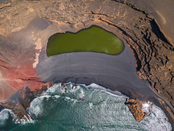 aerial view of the charco de los clicos, a small salt-water lake with an emerald green color. lanzarote, canary islands, spain, europe - lanzarote canary islands volcano green imagens e fotografias de stock