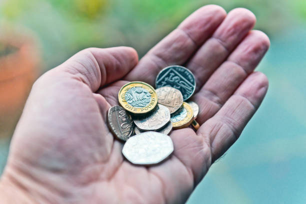 英国のコインを持っている手 - one pound coin ストックフォトと画像