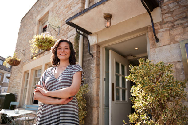 istock Female restaurant pub owner standing outside her business 1068395184