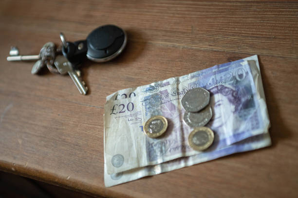 British currency on  a table British currency, twenty pound notes and pound coins on a dining table. twenty pound note stock pictures, royalty-free photos & images