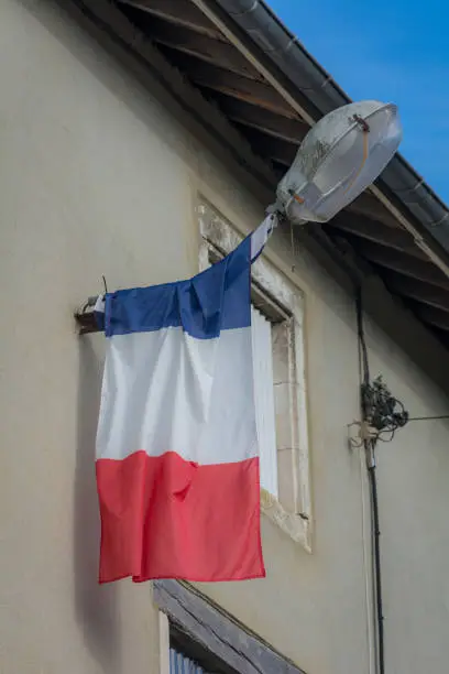 French national flag on streetlight against building