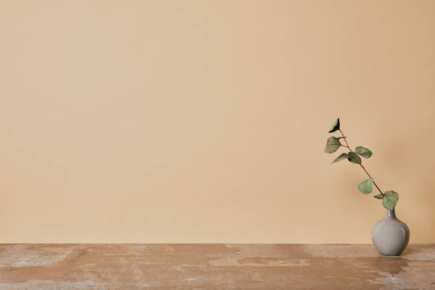 istock Vase with flower on table on beige background 1068407512
