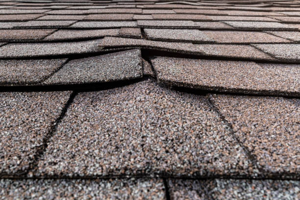 A close-up of a buckled residential asphalt shingled roof stock photo