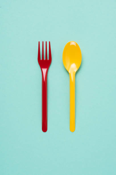 istock Top view of red plastic fork and yellow spoon on blue background 1068412064