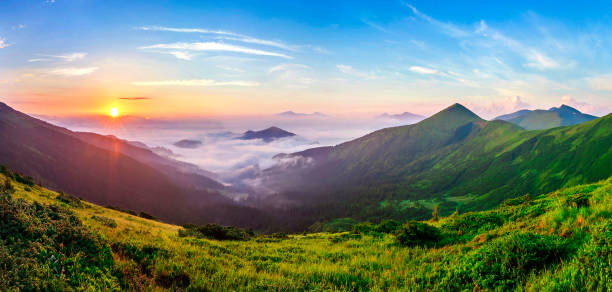 istock Beautiful sunrise in mountains with white fog below panorama 1068416154
