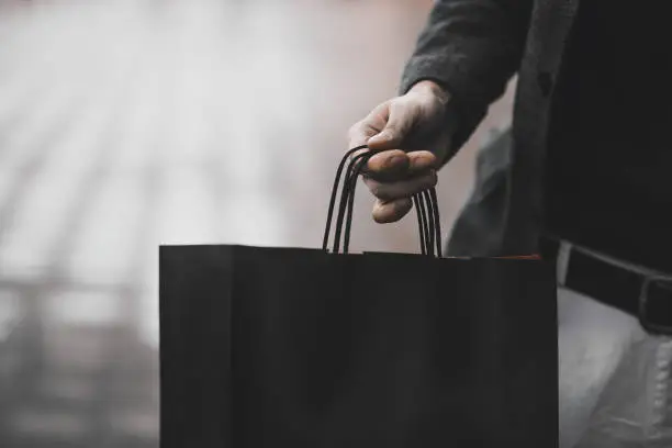 Photo of Close up of paper shopping bags in male hand.