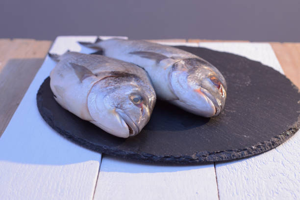 istock two dorado fish on a black plate 1068420730