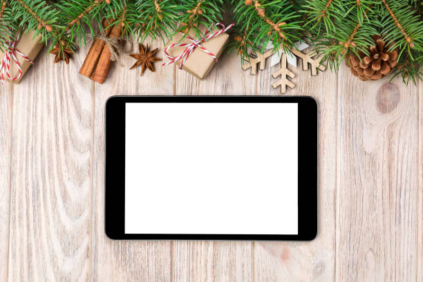 istock Digital tablet mock up with rustic Christmas wood background decorations for app presentation. top view with copy space 1068424614