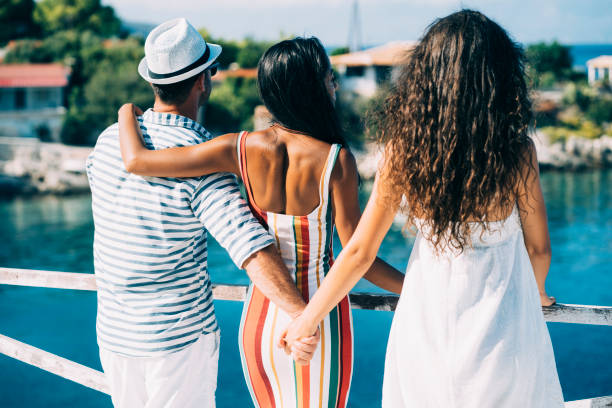 Summer love triangle Couple in vacations standing on harbor, man hoding other woman's hand. relationship breakup photos stock pictures, royalty-free photos & images