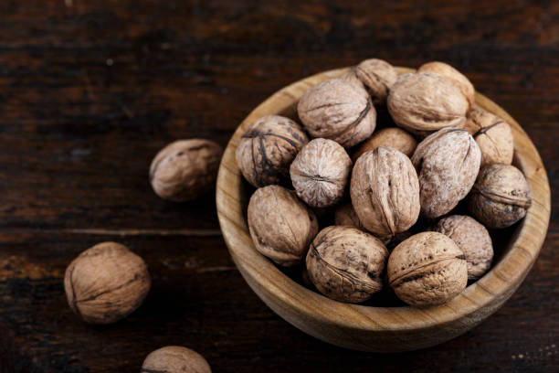 istock inshell whole walnuts on dark wooden background. 1068427926