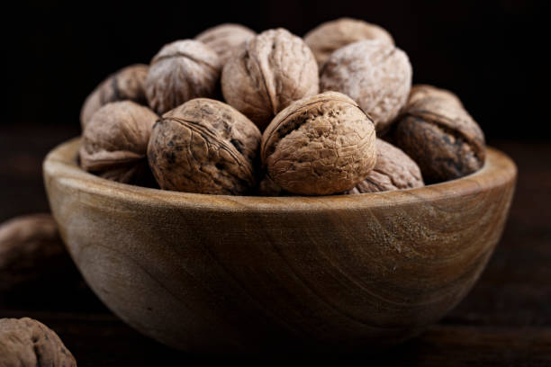 istock inshell whole walnuts on dark wooden background. 1068427964
