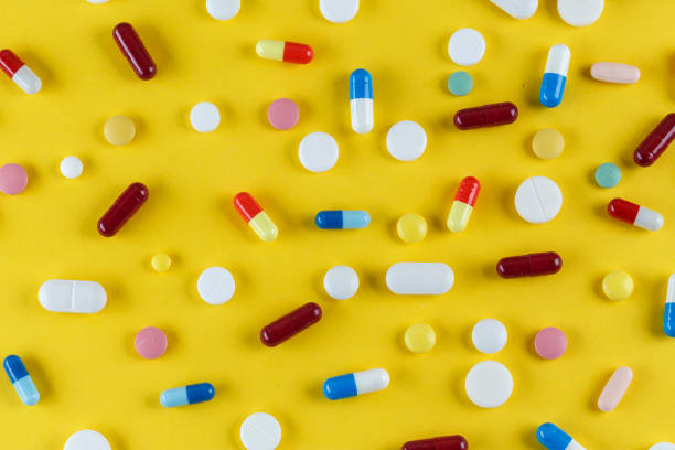 istock different pills and capsules scattered on a yellow background 1068436348