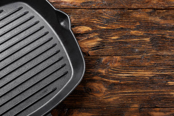 istock empty net cast iron grill pan on wooden background. 1068436534
