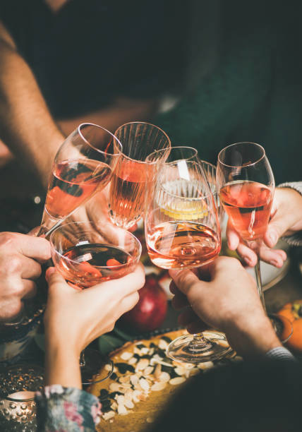 istock Friends clinking glasses with rose wine at Christmas table 1068436990