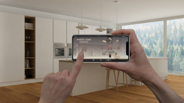 istock Remote home control system on a digital smart phone tablet. Device with app icons. Interior of modern minimalist white and wooden kitchen in the background, architecture design 1068437118