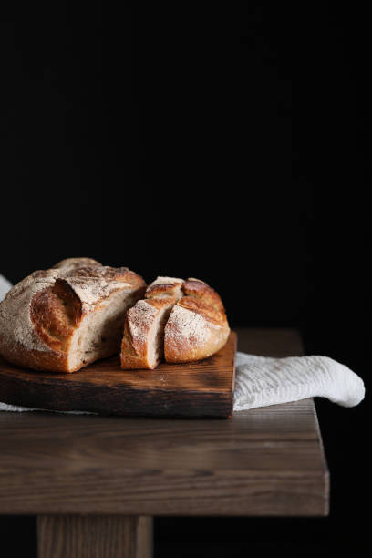 istock Bread at wood board with napkin on dark background 1068439582
