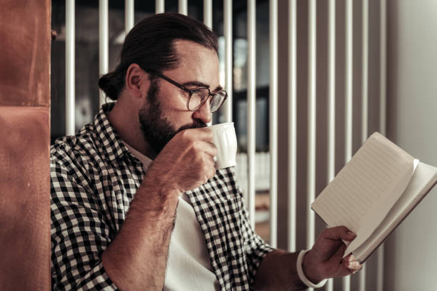 istock Nice positive man taking a sip of coffee 1068439660
