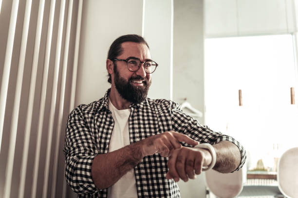 istock Delighted bearded man pressing a button on his watch 1068439676