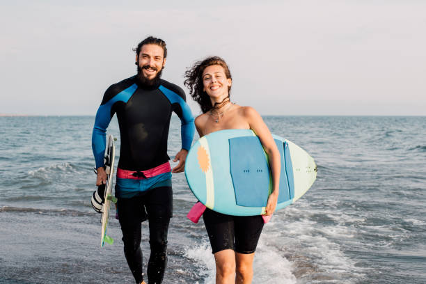 istock Happy people holding surfing boards 1068440298