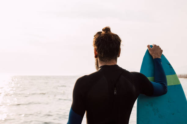istock Man with surfing board at the beach 1068440416