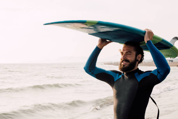 istock Happy young surfer with surfing board 1068441928