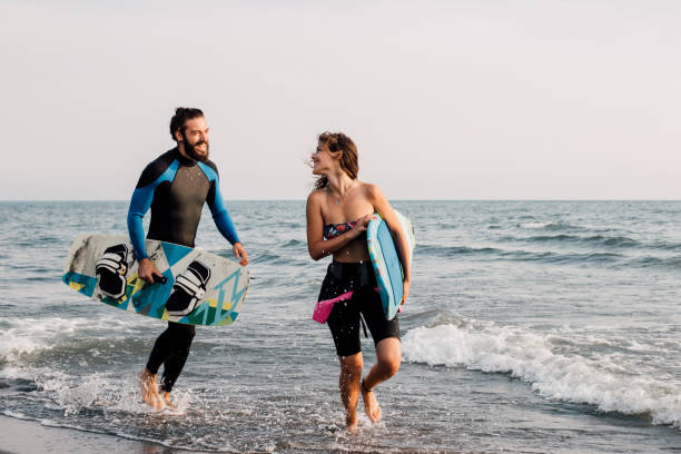 istock Surfing couple running at the beach 1068441986