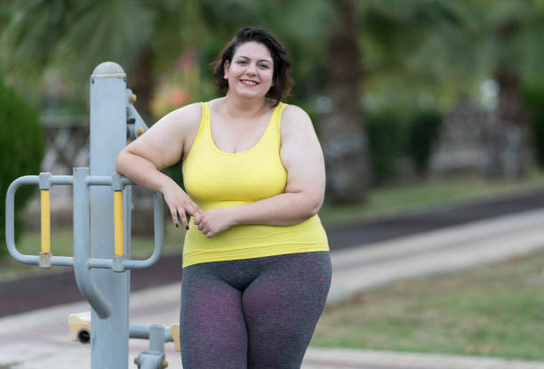Young oversized woman exercising in the park