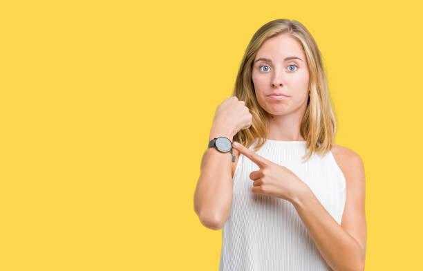 bella mujer elegante sobre fondo aislado en prisa señalar para ver tiempo, impaciencia, malestar y enfadado por el retraso de la fecha límite - impaciencia fotografías e imágenes de stock