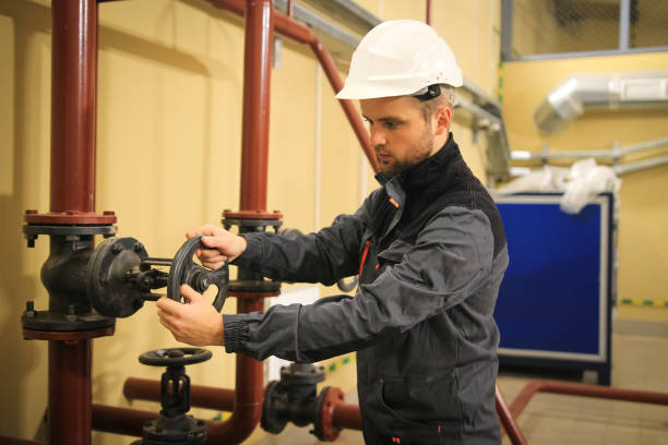 istock Engineer closes gate valve on industrial pipeline 1068453266