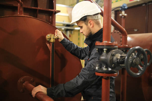 ingeniero mecánico en instalaciones de petróleo y gas. trabajo de servicio en el tanque de agua técnica. - water valve oil gas fotografías e imágenes de stock
