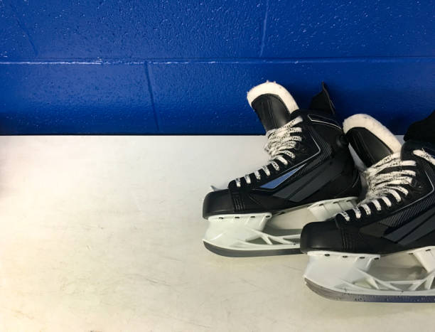 istock Hockey skates over white bench in locker room with copy space 1068455340