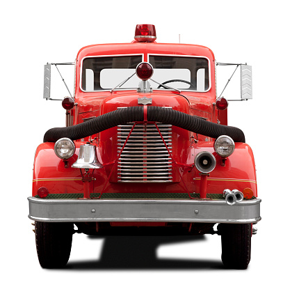 This is a front view of a old antique red fire truck facing the camera isolated on a white background. There is a drop shadow included with this photo